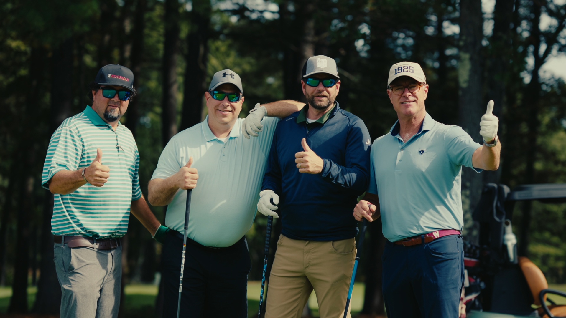 Foursome posing with thumbs up before tee-off