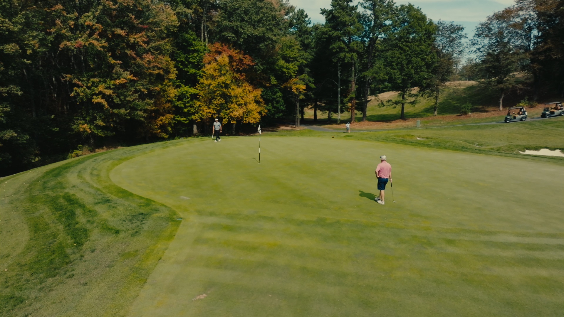 Players on the green lining up a putt