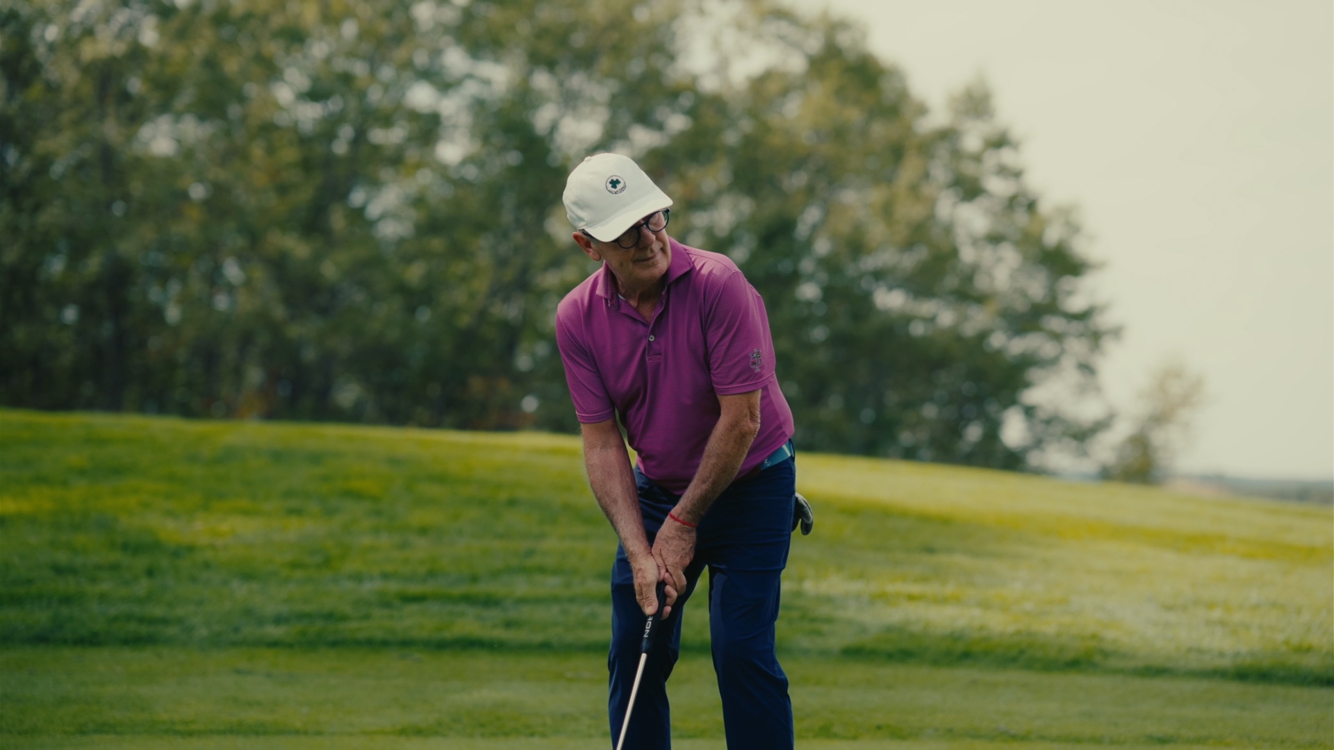 Player setting up over the ball on the fairway