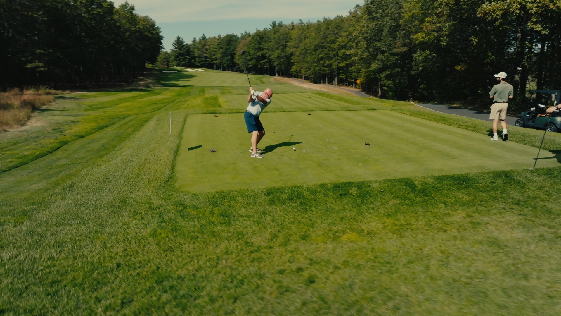 Golfer mid-swing on the tee box